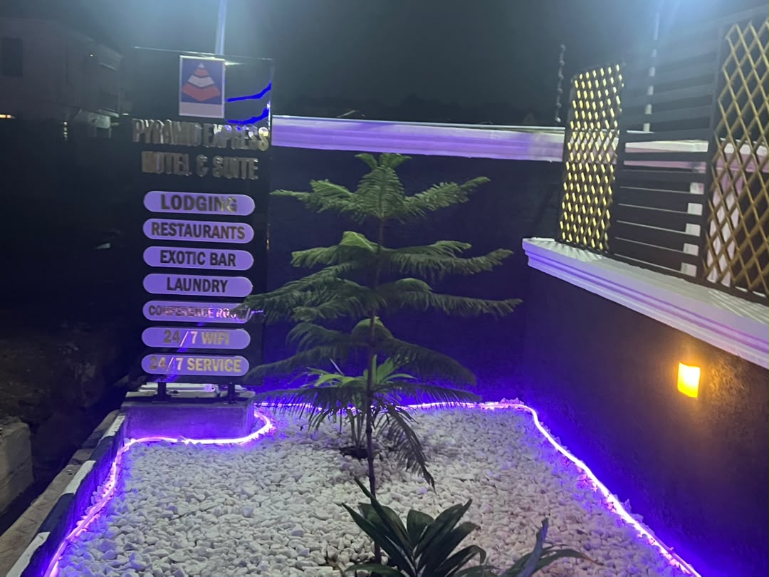 Illuminated Pyramid Express Motel & Suite entrance signage at night